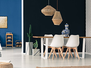 Dark Bold dining setting with pop of blue paired with light white and wooden furniture and plants